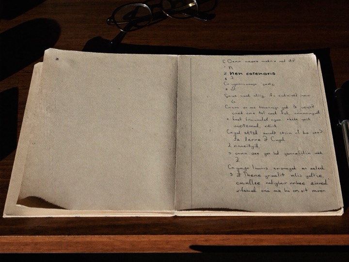 A bound clinical report resting closed on a desk beside reading glasses